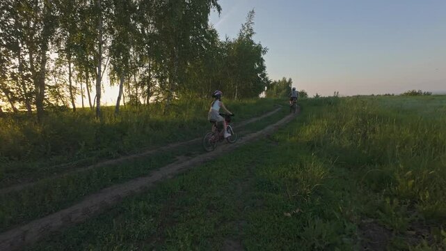 woman with daughter riding bicycles through fields, family trip