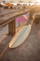 Beige surfboard in the sun. Surfer shortboard on a concrete background in the rays of the setting sun. The concept of sport and surfing on the islands