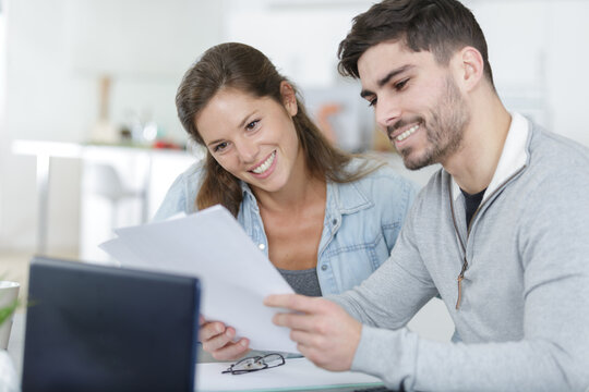happy beautiful couple managing their bills at home