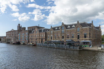 This grand waterside view captures the historic "Batavia" warehouse in Wormer, Netherlands, showcasing its stately architecture and reflecting the industrial heritage. Wormer, Netherlands