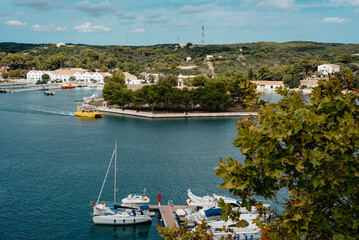 Yellow boat approaching Isla del Rey in Mahón harbor, Menorca