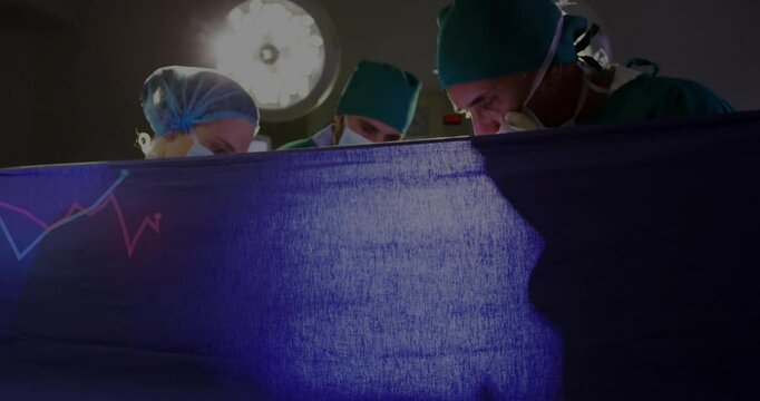 Blue drape settling under surgical light, team adjusting tools while monitoring vital sign graph