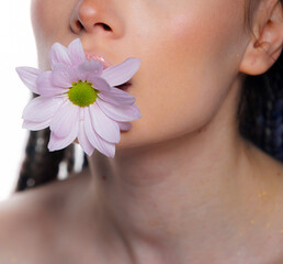 Woman body parts with  medical plaster holds flowers. Closeup face of young beautiful woman with a healthy  skin. Body care and health concept