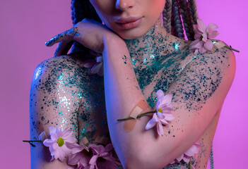 Woman body parts with  medical plaster holds flowers. Closeup face of young beautiful woman with a healthy  skin. Body care and health concept
