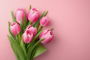 Fototapeta premium A bouquet of pink tulips is arranged on a pink background. The flowers are the main focus of the image, and they are arranged in a way that creates a sense of harmony and balance