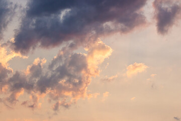 cumulus clouds on the sky blown by the wind. warm scenery. cloudy weather meteorology background in orange glow. evening mood