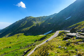 romania travel landscape with road in summer. beautiful mountain road that crosses southern carpathians. touristic destination of europe. sunny day with blue sky and fluffy clouds