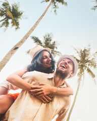 Carefree caucasian happy couple enjoying moment being playful piggyback ride during honeymoon...