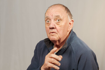 portrait vieil homme donnant son avis sur fond gris