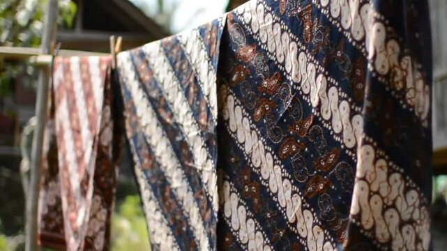 Batik cloth waves in wind, traditional fabric, village view