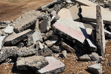 pile of broken asphalt and concrete debris on dirt ground, construction waste, concept of...