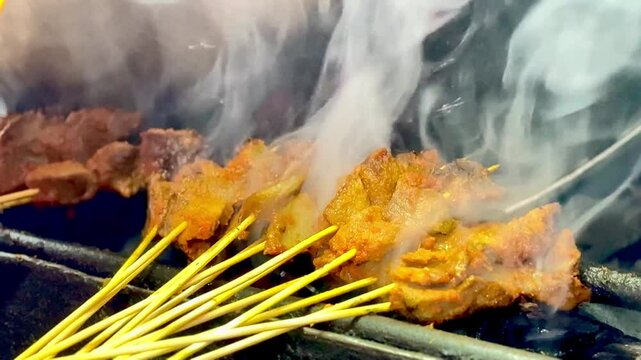 Sate Padang or Padangnese skewers being grilled at a street vendor.