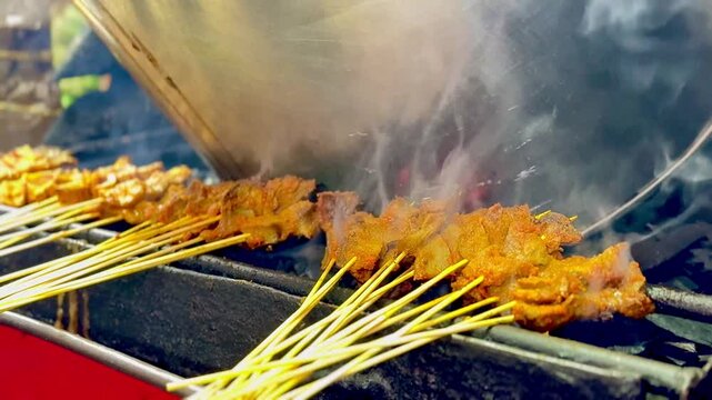 Sate Padang or Padangnese skewers being grilled at a street vendor.