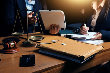 Attractive young lawyer in office Business woman and lawyers discussing contract papers with brass scale on wooden desk in office. Law, legal services, advice, Justice and real estate concept.