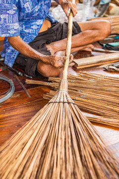 Finished handmade coconut broom proudly displayed by Thai artisan