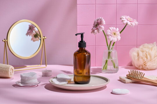 A bathroom scene with beauty products, flowers, and a mirror