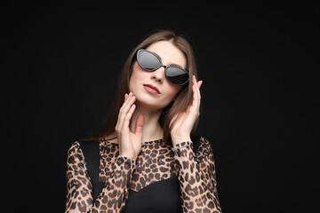 Obraz premium Fashionable portrait of beautiful woman in stylish outfit on black background