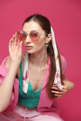 Fashionable portrait of beautiful woman in stylish outfit on pink background