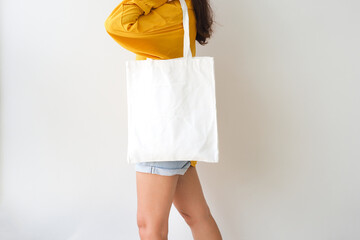 Woman holding canvas tote bag on white background. Reusable eco bag for shopping. Eco friendly...
