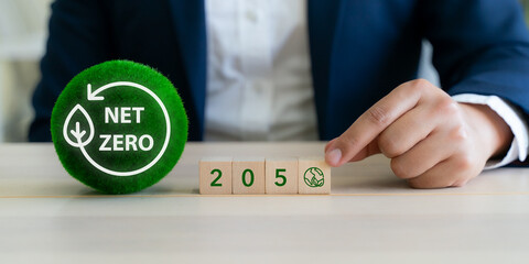 Net Zero by 2050 concept. A business themed image symbolizing a commitment to achieving net zero emissions by the year 2050, featuring a green sphere with a net zero icon and wooden blocks year 2050.