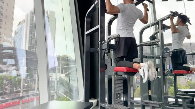 Gym Workout with Pull-Up Machine in Modern Fitness Center