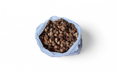 A plastic bag filled with gingers is placed on a white background. The gingers appear fresh and ready to use.