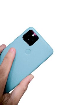 A hand holds a light blue smartphone with a black camera module and a fingerprint scanner on a white background.