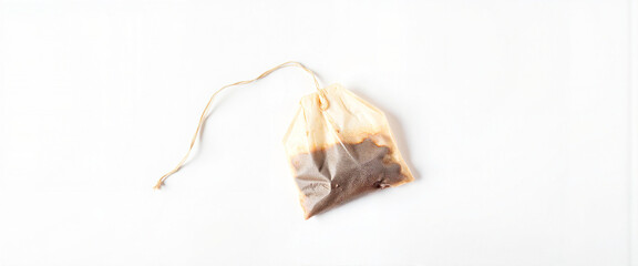 Fototapeta premium Used tea bag with visible stains on white background, everyday ritual
