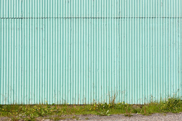 Corrugated facade metalllic wall outdoor in green color. Textured background