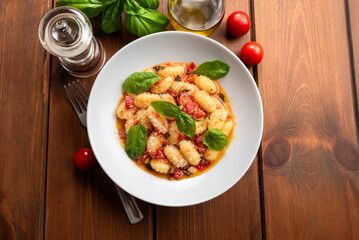 Gnocchi di patate con sugo, olio di oliva, parmigiano e basilico, cibo italiano 