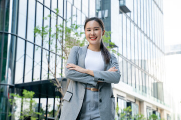 Young adult business working asian woman using digital tablet for online application on day.Asia Business female standing or walking on big city urban street outside.City Streets With People concept