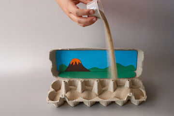 Creative kids craft with volcano diorama, sand pouring step in egg carton, combining science and...
