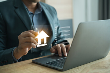 Businessman Using Laptop to Access Real Estate Information with House Icon and Data Elements in Modern Office Environment