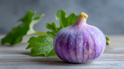 Fototapeta premium Fresh Purple Fig with Green Leaves on Wooden Surface