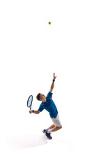 Young male tennis player wearing stylish blue-white uniform making dynamic serve movement against...