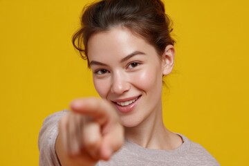 Young woman pointing at camera with cheerful expression