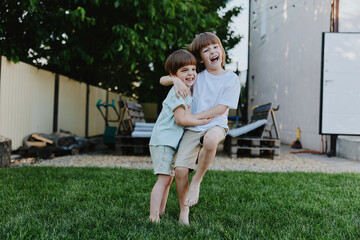 Happy boys playing together in a sunny garden, enjoying friendship and laughter with carefree smiles. Perfect for family-themed concepts and childhood memories.
