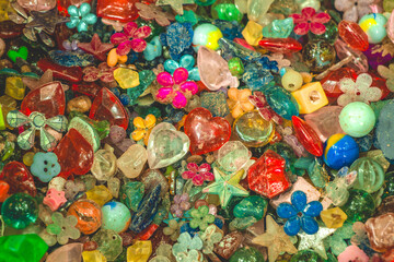 Colorful collection of sparkling beads and gems scattered artistically on a wooden surface