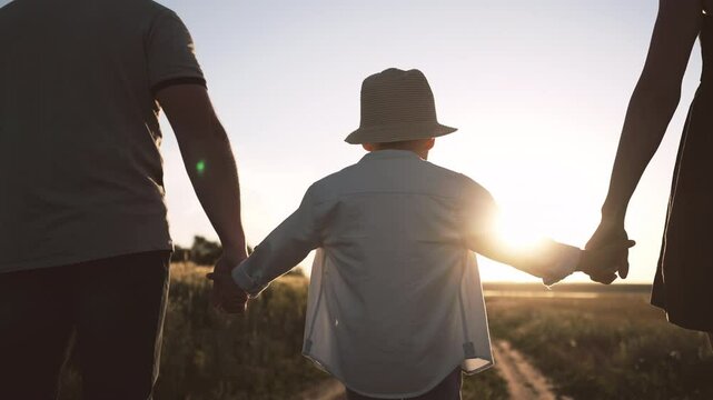 Child connecting divorced spouses, holding hands of mom and dad, family ties. Parenthood and childhood concept, little boy touching hands of mother and father, family relations, happy moments of life