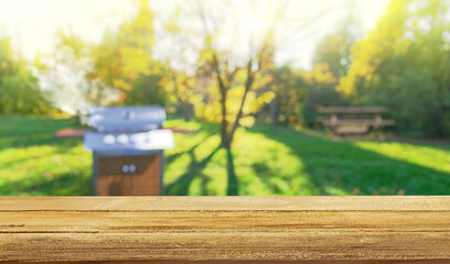 summer time in backyard garden with grill BBQ, wooden table, blurred background
