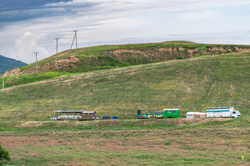 Mobile apiary with beehives on a hill near flowering sainfoin fields.