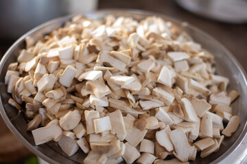 Mushrooms are sliced ​​and placed on a metal tray.