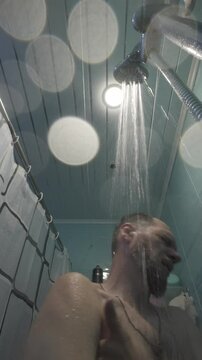 bearded middle aged man washing himself under shower in bathroom, hygiene and body care