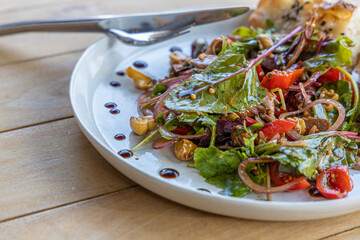 meat salad, bacon, egg, crouton, lettuce, salad dressing vinaigrette  saladcopy space food background rustic top view