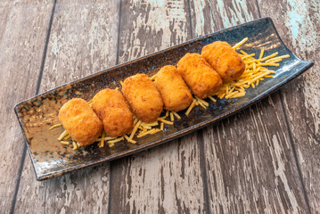 The outer layer, usually breadcrumbs, should be golden, fine, and exceptionally crispy to the bite. This textural contrast is critical to the croquette experience