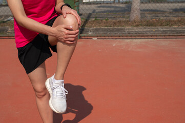 Cropped shot view of female runner holding her leg after suffering from knee pain. Knee pain...