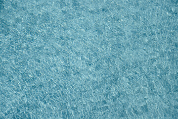 Vibrant blue water surface with shimmering reflections and ripples under sunlight