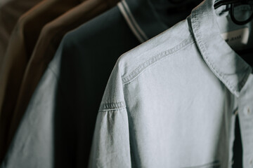 Soft fabric shirts displayed on hangers in a minimalist setting during the afternoon light