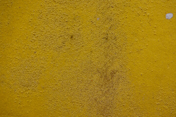 close-up shot of a textured gold yellow concrete surface. The rough and slightly uneven texture, along with subtle variations in the gold yellow hue, creates a visually interesting background.