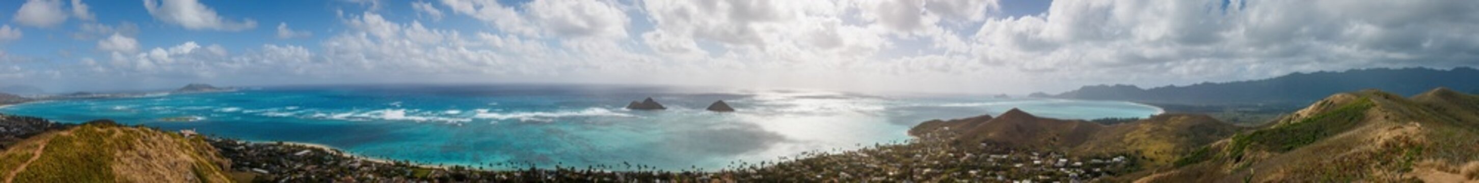 Panoramic view of famous Lanikai Beach in Kailua on the island of Oahu, Hawaii, USA with Mokulua Islands or Twin Islands against blue sky with clouds